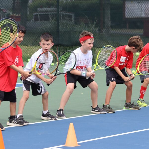 kids lined up holding their tennis rackets