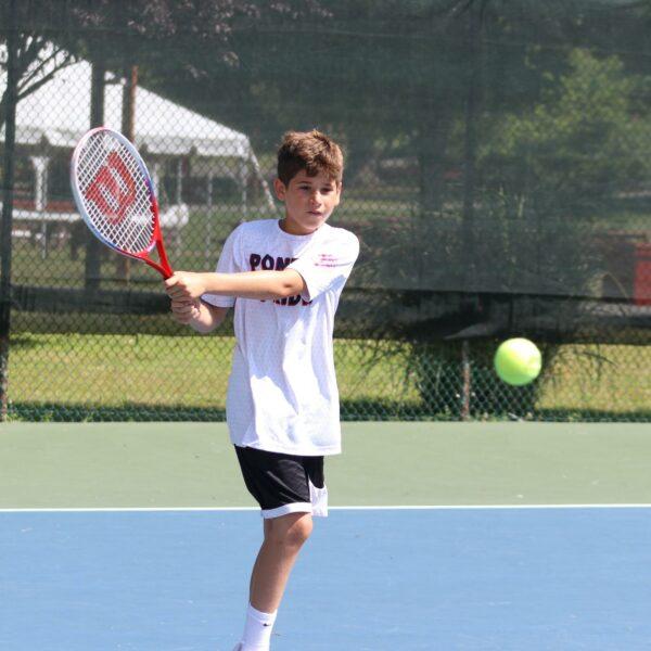 boy about to hit a tennis ball