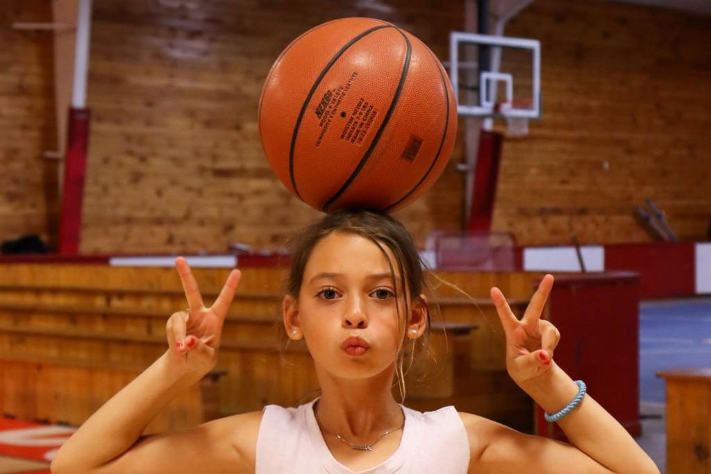 Girl balancing basketball on her head