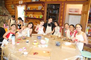 Table of girls doing arts and crafts at summer camp.